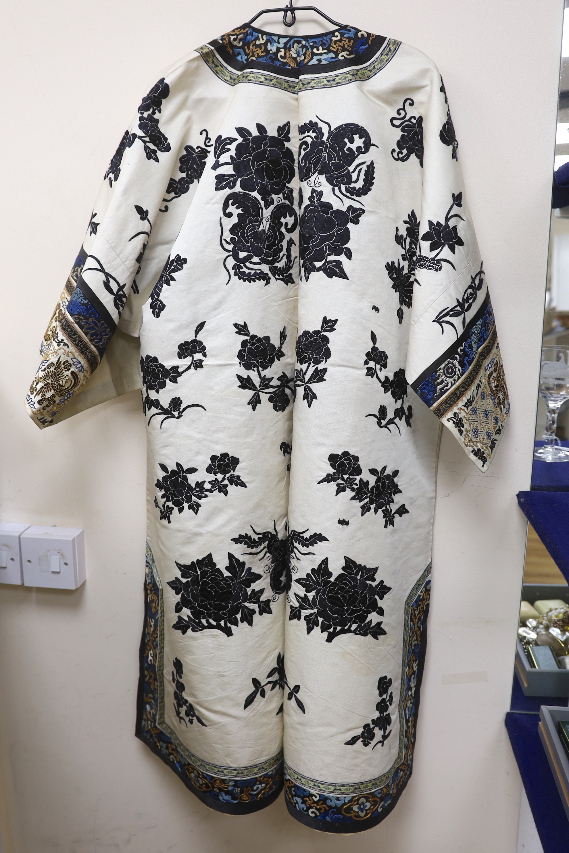 A late 19th/early 20th century Chinese embroidered cream silk robe with black symbolic embroidered all over motifs